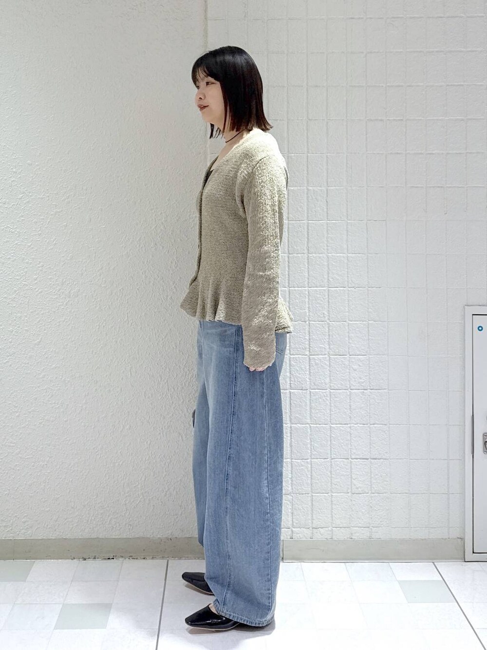 ブルー系のデニムパンツ、ブラック系のショルダーバッグ、ブラック系のパンプスを着用したレディースの春コーディネートの4枚目の写真