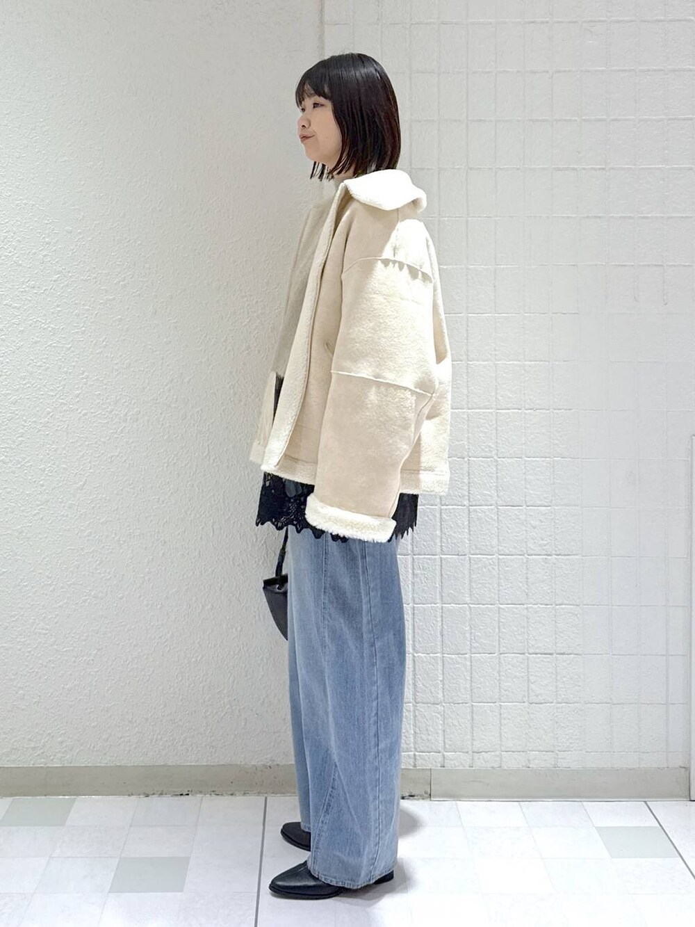 ベージュ系のニット/セーター、ブルー系のデニムパンツ、ブラック系のブーツを着用したレディースの冬コーディネートの4枚目の写真