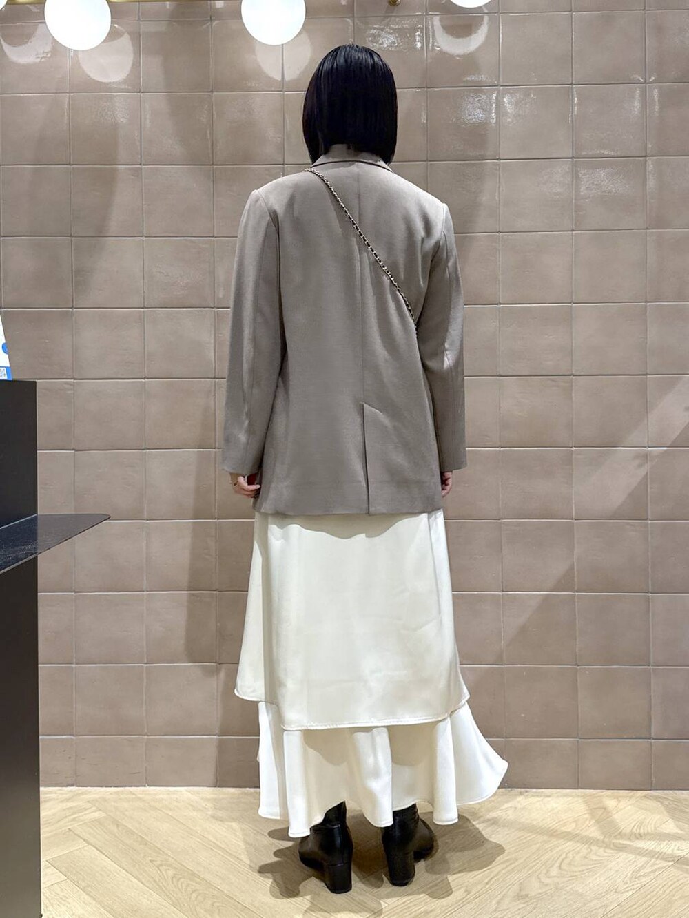 ブラック系のブーツ、グレー系のテーラードジャケット、ホワイト系のワンピースを着用したレディースの秋コーディネートの4枚目の写真