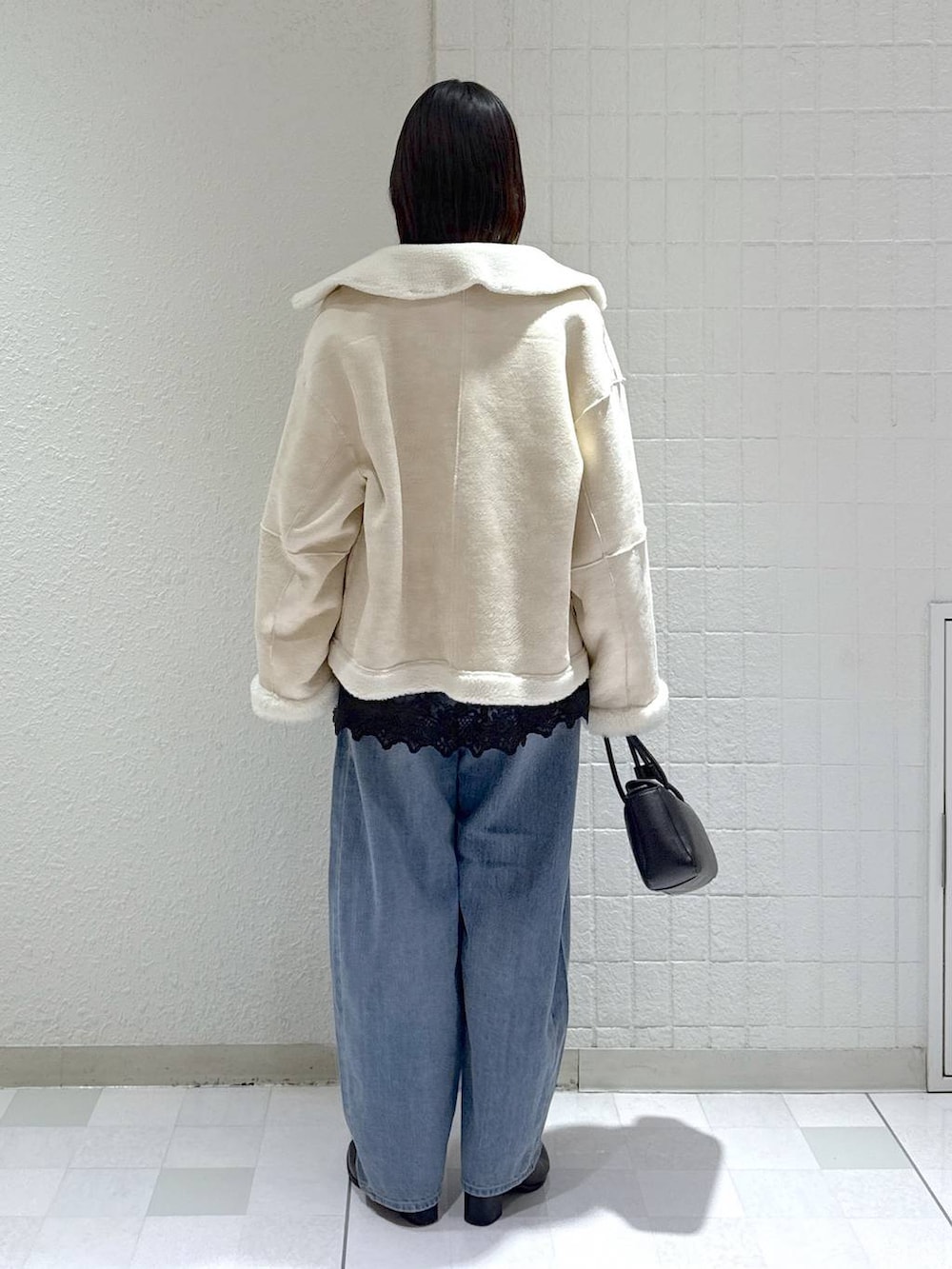 ベージュ系のニット/セーター、ブルー系のデニムパンツ、ブラック系のブーツを着用したレディースの冬コーディネートの3枚目の写真