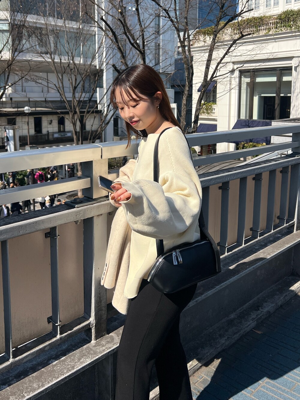 ホワイト系のニット/セーター、ベージュ系のテーラードジャケット、ブラック系のショルダーバッグを着用したレディースの春コーディネートの4枚目の写真