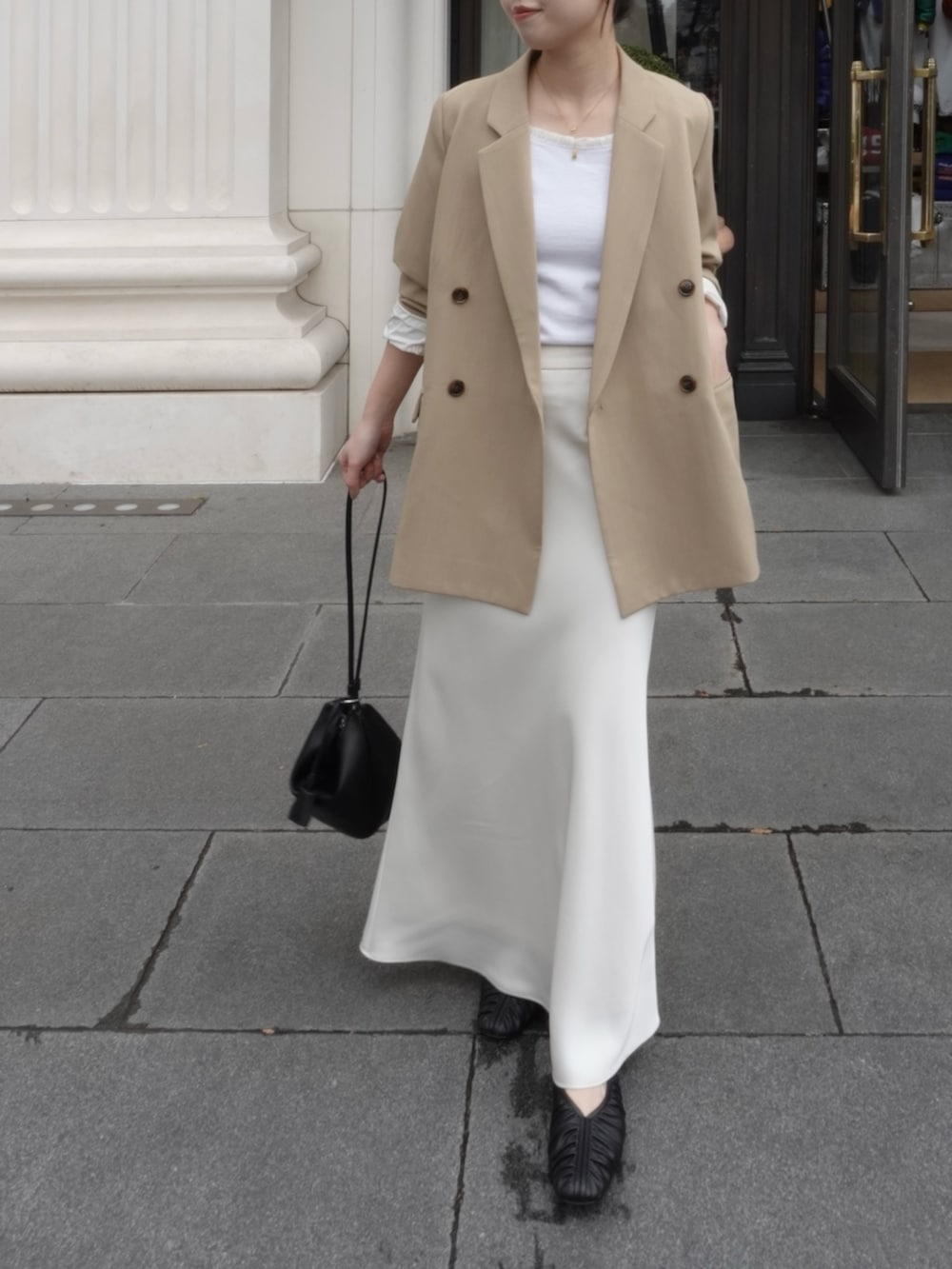 ホワイト系のTシャツ/カットソー、ベージュ系のテーラードジャケット、ホワイト系のスカートを着用したレディースの春コーディネートの3枚目の写真