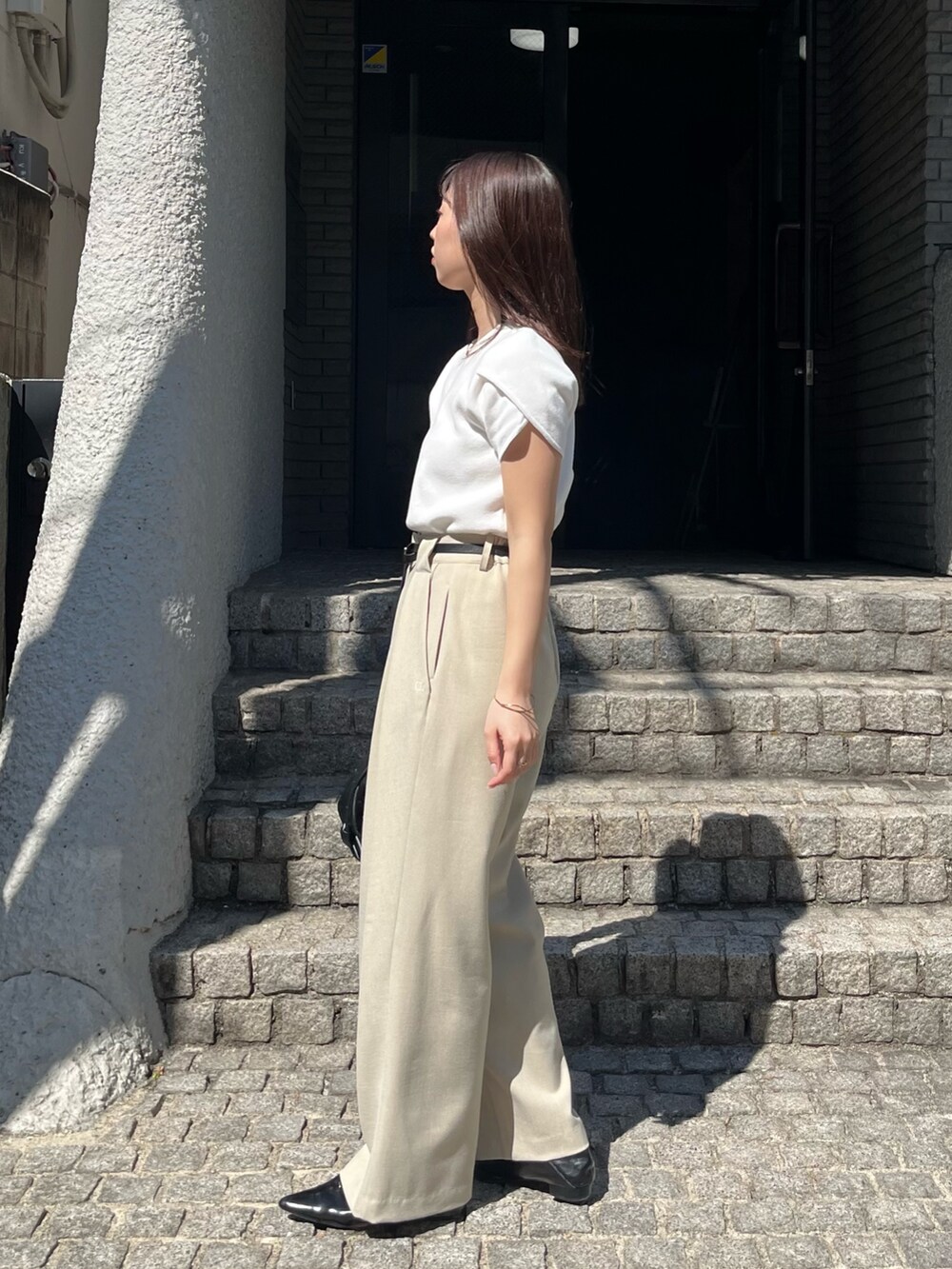 ホワイト系のニット/セーター、ベージュ系のその他パンツ、ブラック系のショルダーバッグを着用したレディースの春コーディネートの4枚目の写真