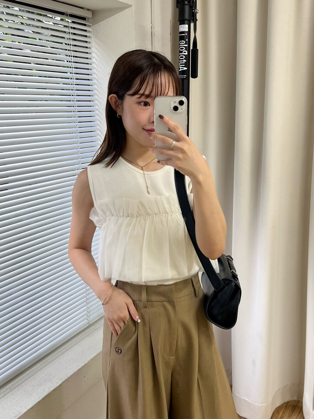 ホワイト系のニット/セーター、ベージュ系のその他パンツ、ブラック系のショルダーバッグを着用したレディースの夏コーディネートの2枚目の写真