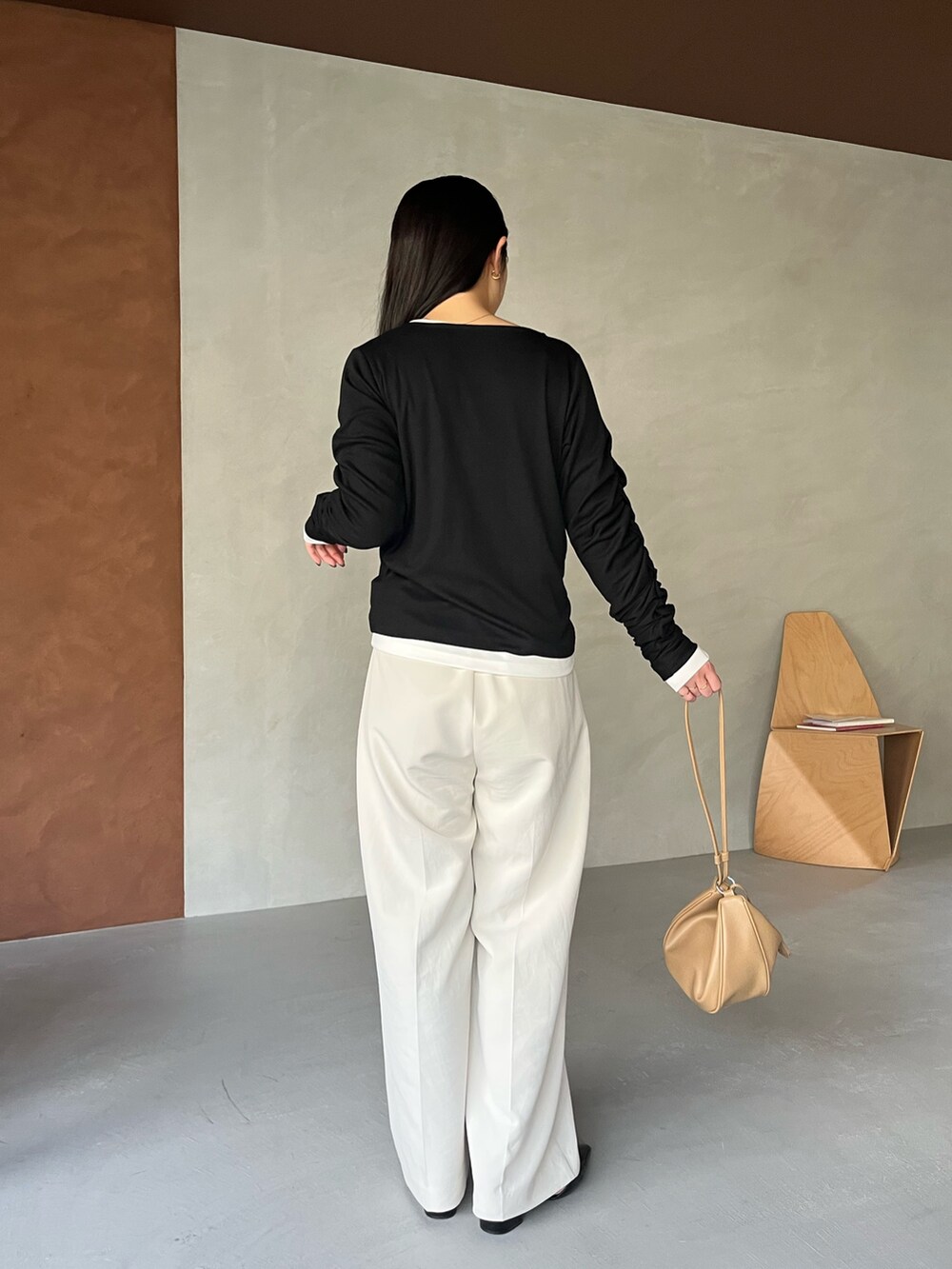 ブラック系のTシャツ/カットソー、ホワイト系のその他パンツ、ベージュ系のショルダーバッグを着用したレディースの冬コーディネートの4枚目の写真