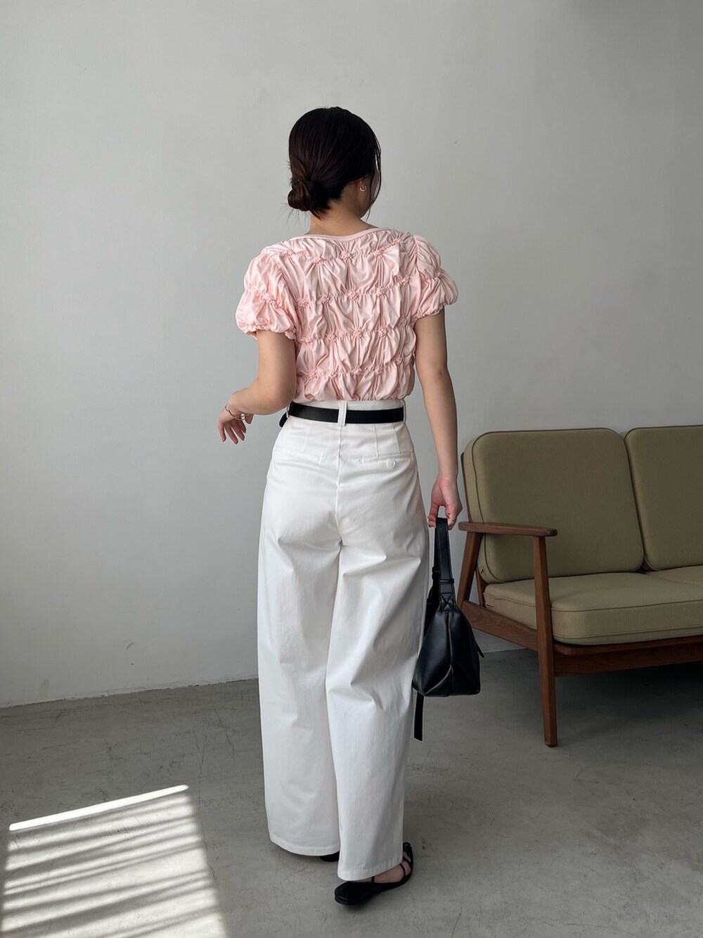 ピンク系のTシャツ/カットソー、ホワイト系のその他パンツ、ブラック系のサンダルを着用したレディースの春コーディネートの4枚目の写真