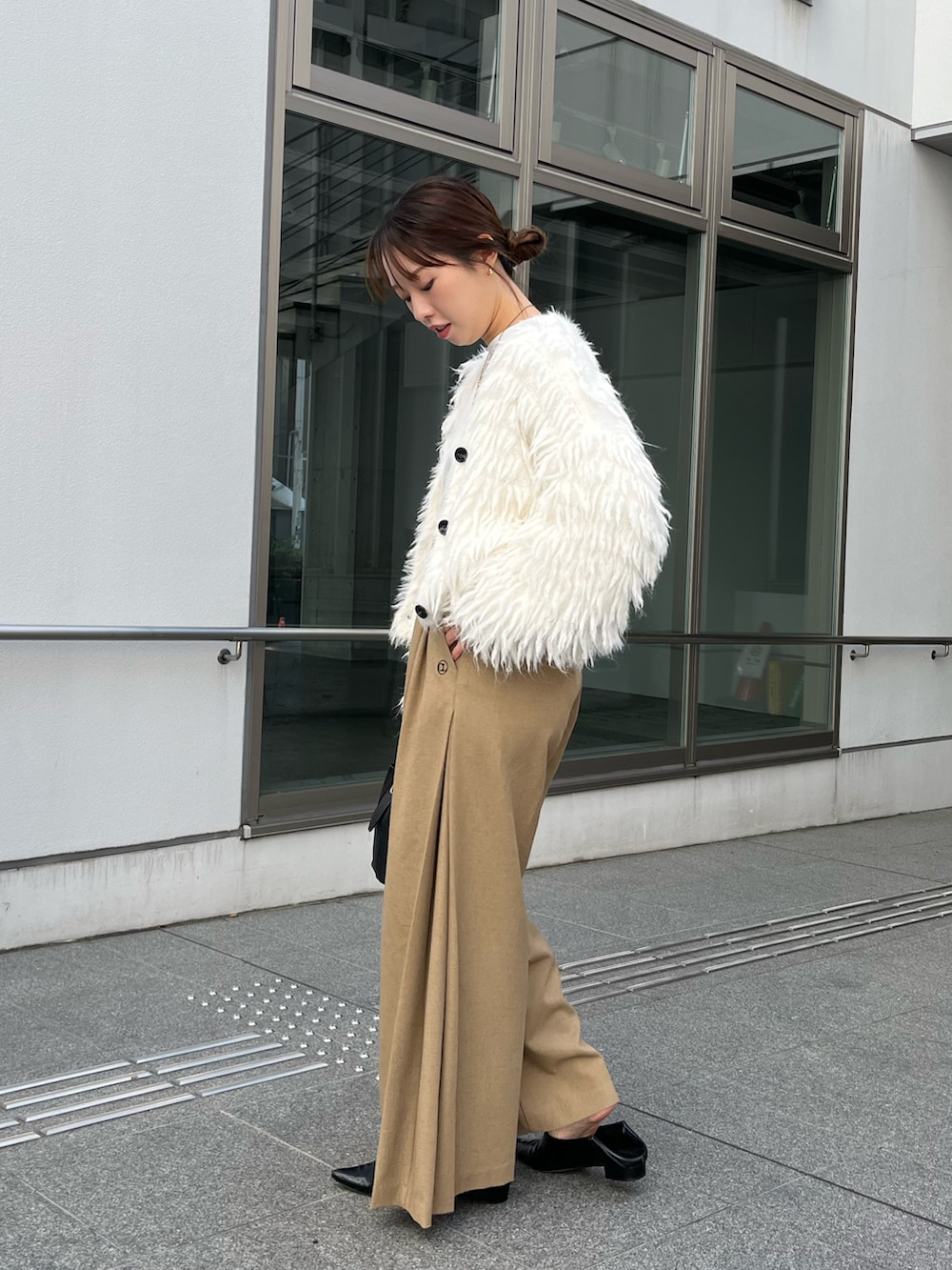 ベージュ系のその他パンツ、ブラック系のショルダーバッグ、ホワイト系のカーディガン/ボレロを着用したレディースの冬コーディネートの3枚目の写真