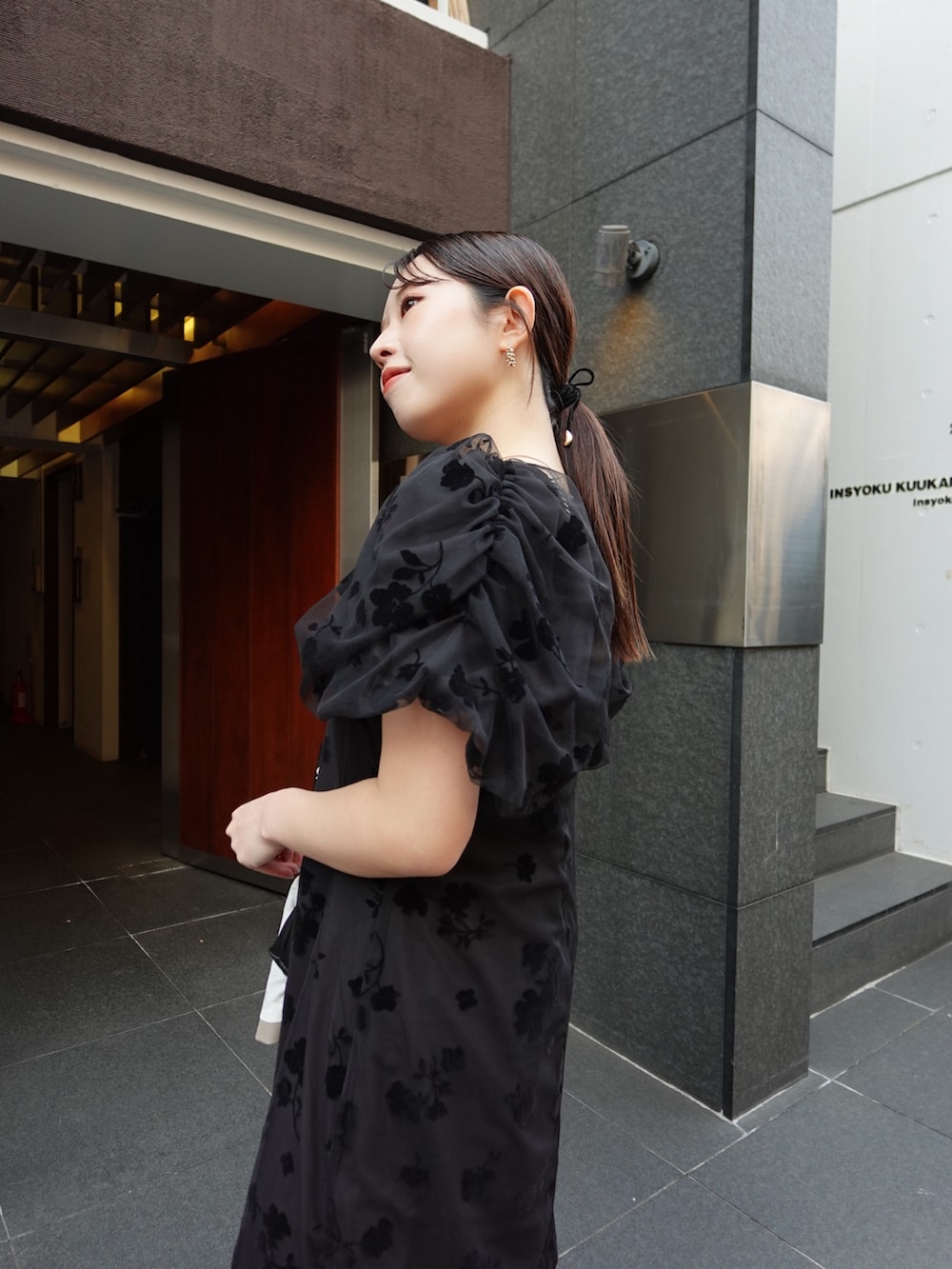 ブラック系のパンプス、ベージュ系のテーラードジャケット、ブラック系のワンピースを着用したレディースの春コーディネートの4枚目の写真