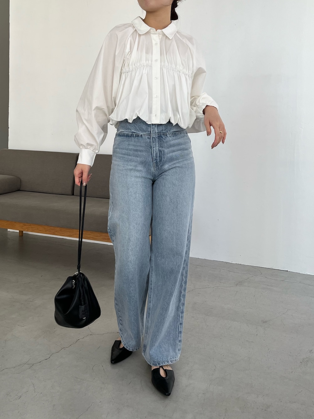 ホワイト系のシャツ/ブラウス、ブルー系のデニムパンツ、ブラック系のパンプスを着用したレディースの春コーディネートの2枚目の写真