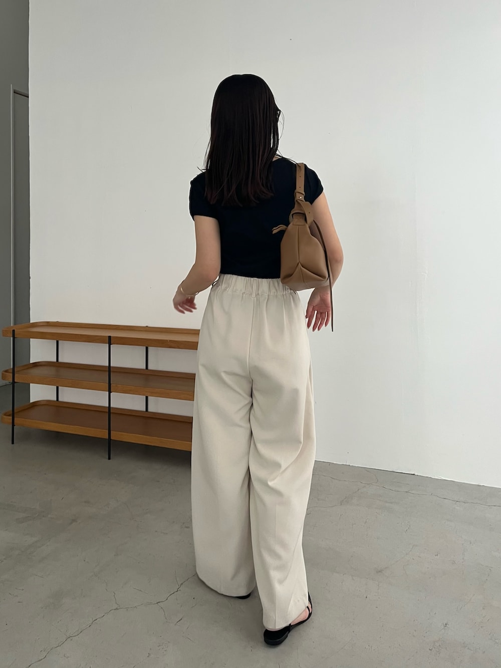 ブラック系のTシャツ/カットソー、ホワイト系のその他パンツ、ブラック系のサンダルを着用したレディースの春コーディネートの4枚目の写真