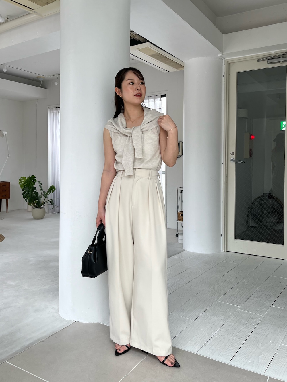 ホワイト系のニット/セーター、ホワイト系のその他パンツ、ブラック系のサンダルを着用したレディースの夏コーディネートの2枚目の写真