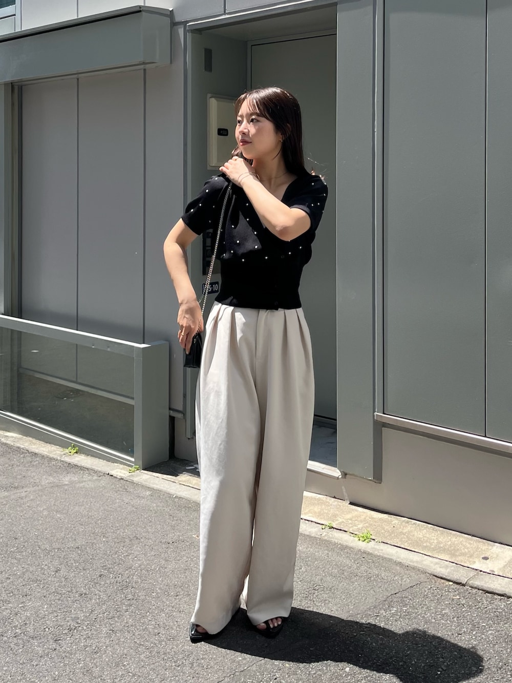 ブラック系のカーディガン/ボレロ、ブラック系のサンダル、ホワイト系のその他パンツを着用したレディースの夏コーディネートの2枚目の写真