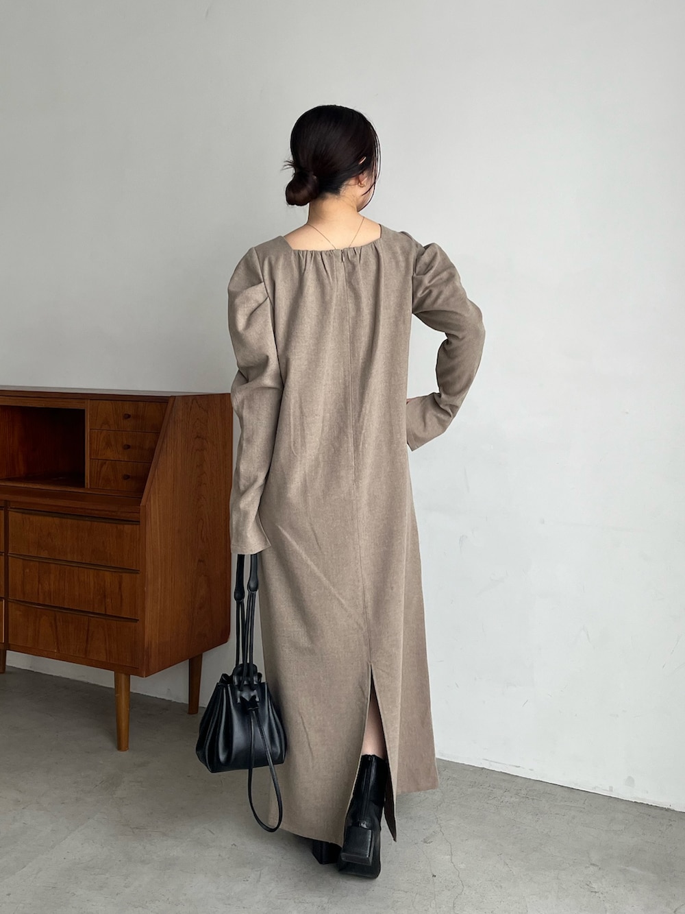 ベージュ系のワンピース、ブラック系のブーツ、ブラック系のショルダーバッグを着用したレディースの冬コーディネートの3枚目の写真