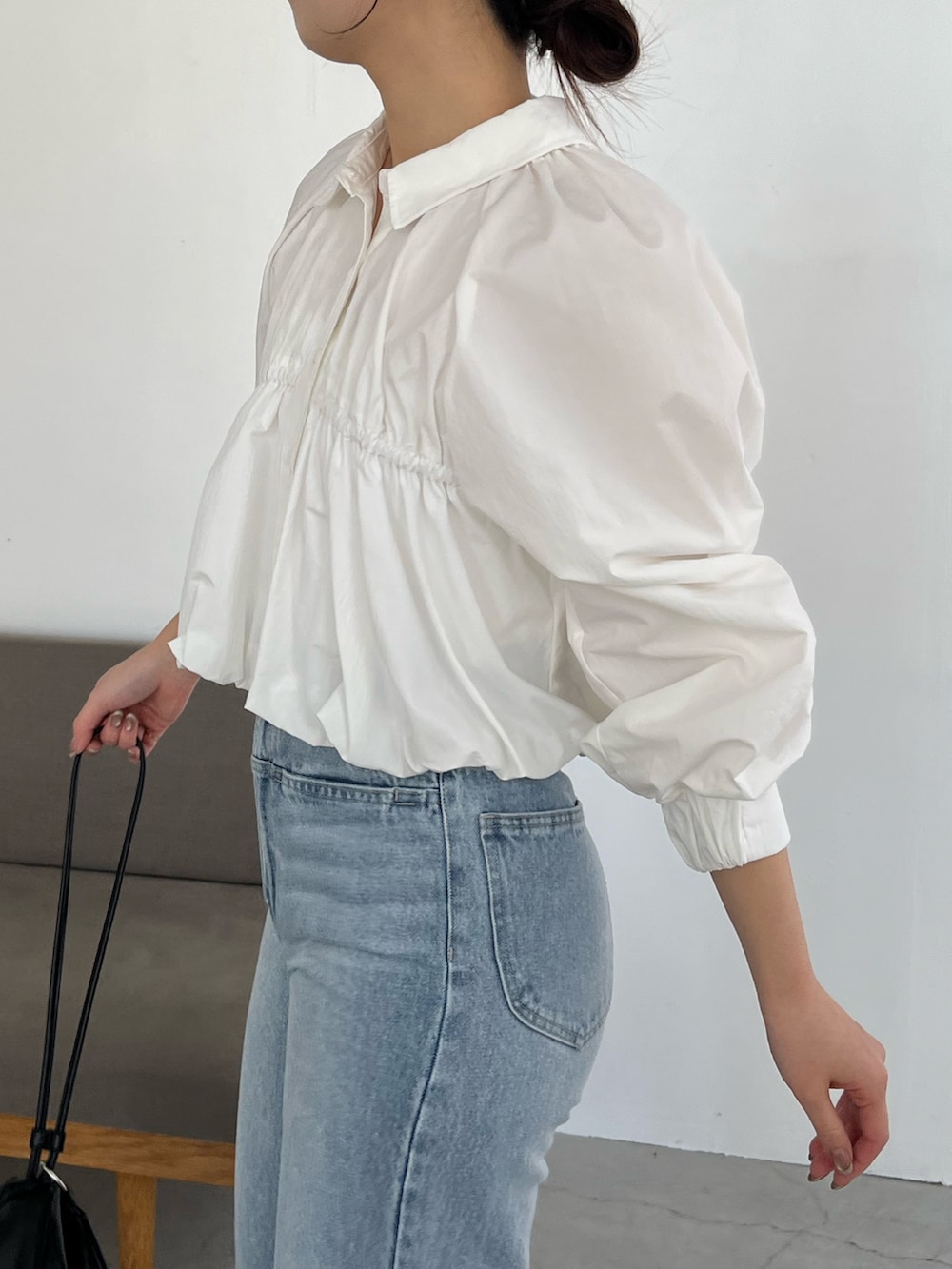 ホワイト系のシャツ/ブラウス、ブルー系のデニムパンツ、ブラック系のパンプスを着用したレディースの春コーディネートの3枚目の写真