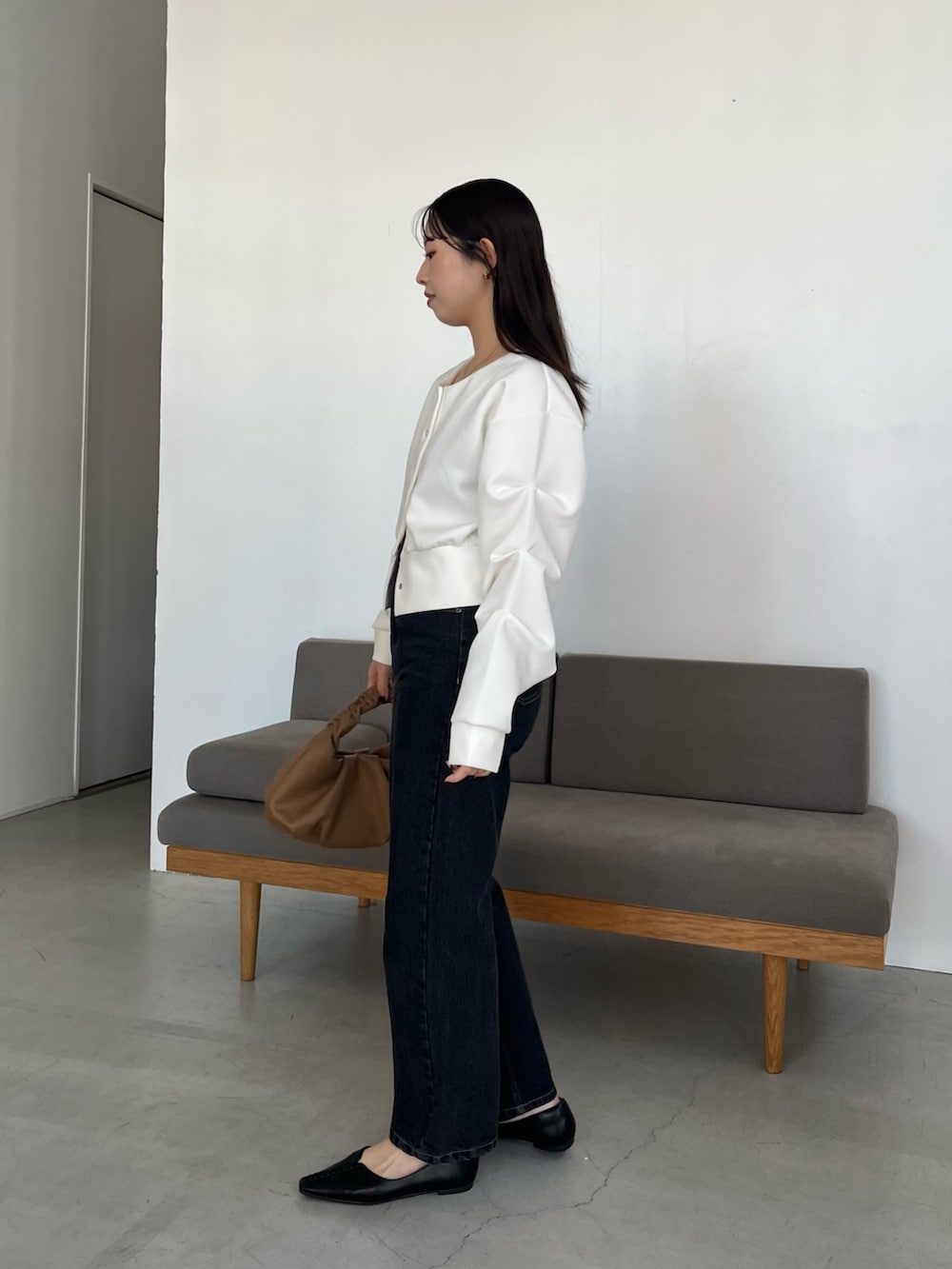 ホワイト系のTシャツ/カットソー、ブラック系のデニムパンツ、イエロー系のショルダーバッグを着用したレディースの冬コーディネートの4枚目の写真