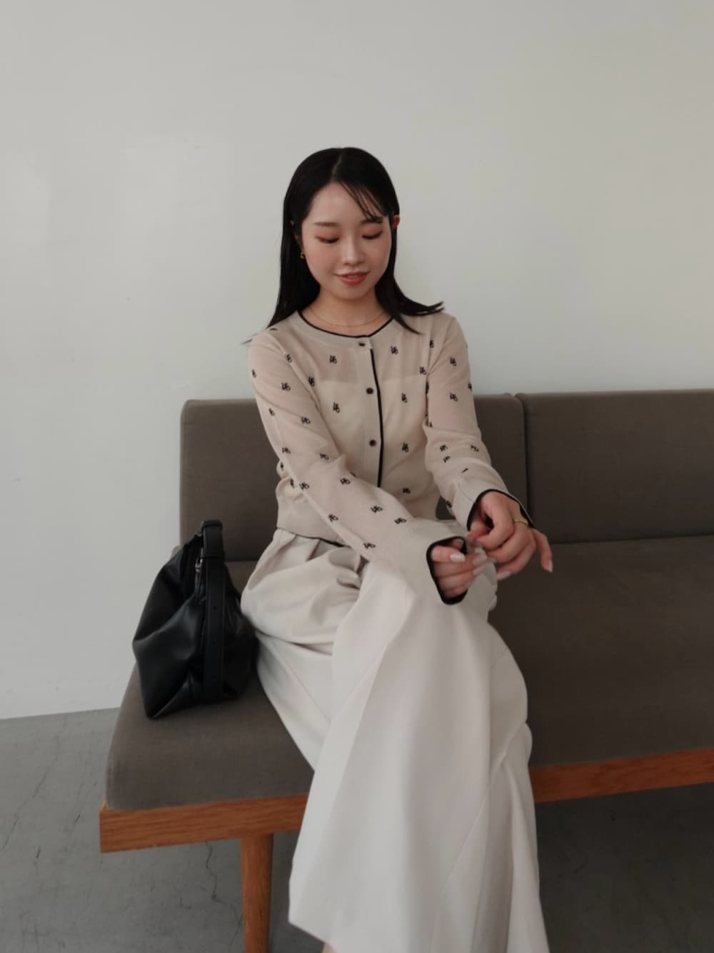 ベージュ系のカーディガン/ボレロ、ホワイト系のその他パンツ、ブラック系のショルダーバッグを着用したレディースの春コーディネートの5枚目の写真