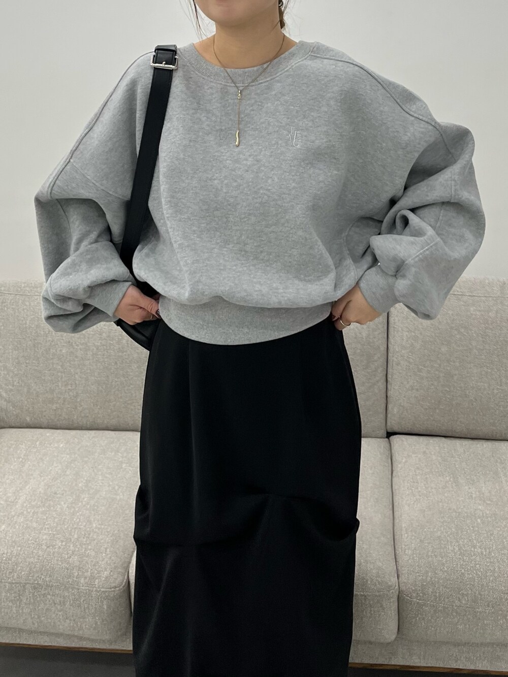 グレー系のTシャツ/カットソー、ブラック系のショルダーバッグ、ブラック系のスカートを着用したレディースの冬コーディネートの5枚目の写真