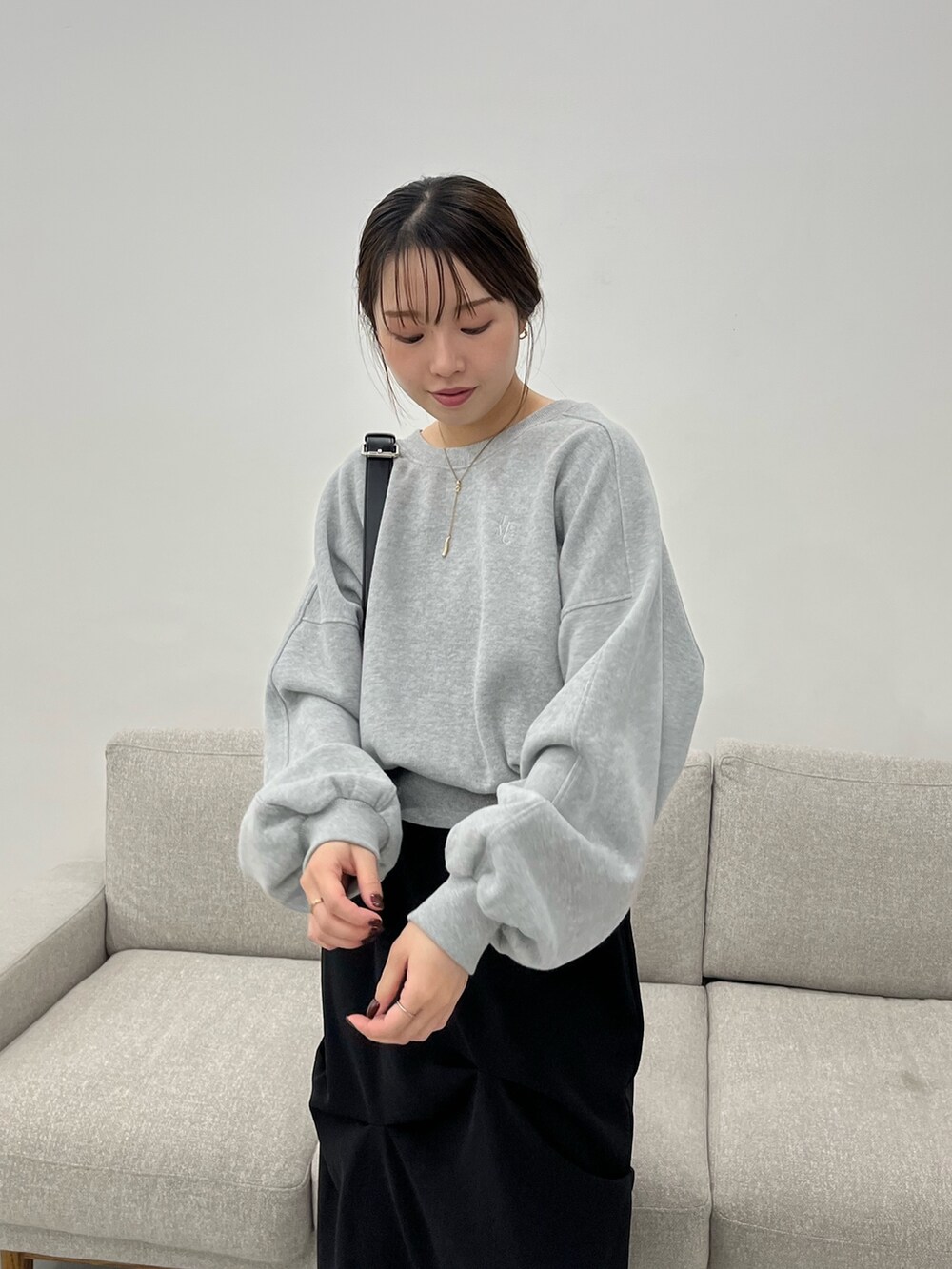 グレー系のTシャツ/カットソー、ブラック系のショルダーバッグ、ブラック系のスカートを着用したレディースの冬コーディネートの4枚目の写真