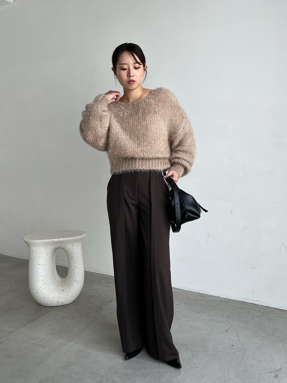 ベージュ系のニット/セーター、ブラウン系のその他パンツ、ブラック系のパンプスを着用したレディースの秋コーディネートの5枚目の写真