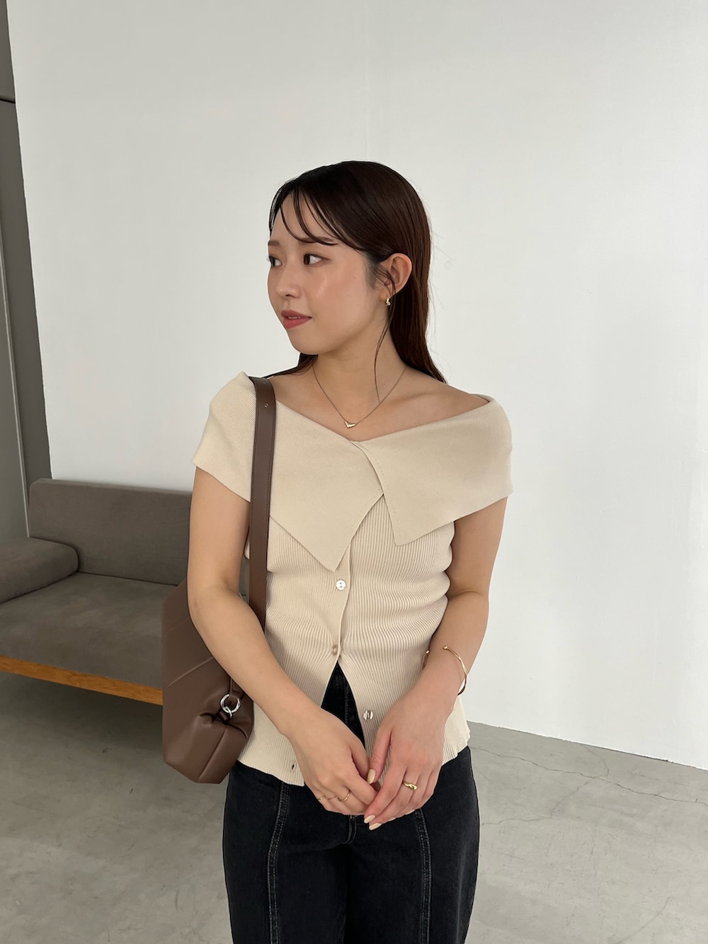 ブラック系のデニムパンツ、ベージュ系のニット/セーター、ブラック系のサンダルを着用したレディースの夏コーディネートの3枚目の写真