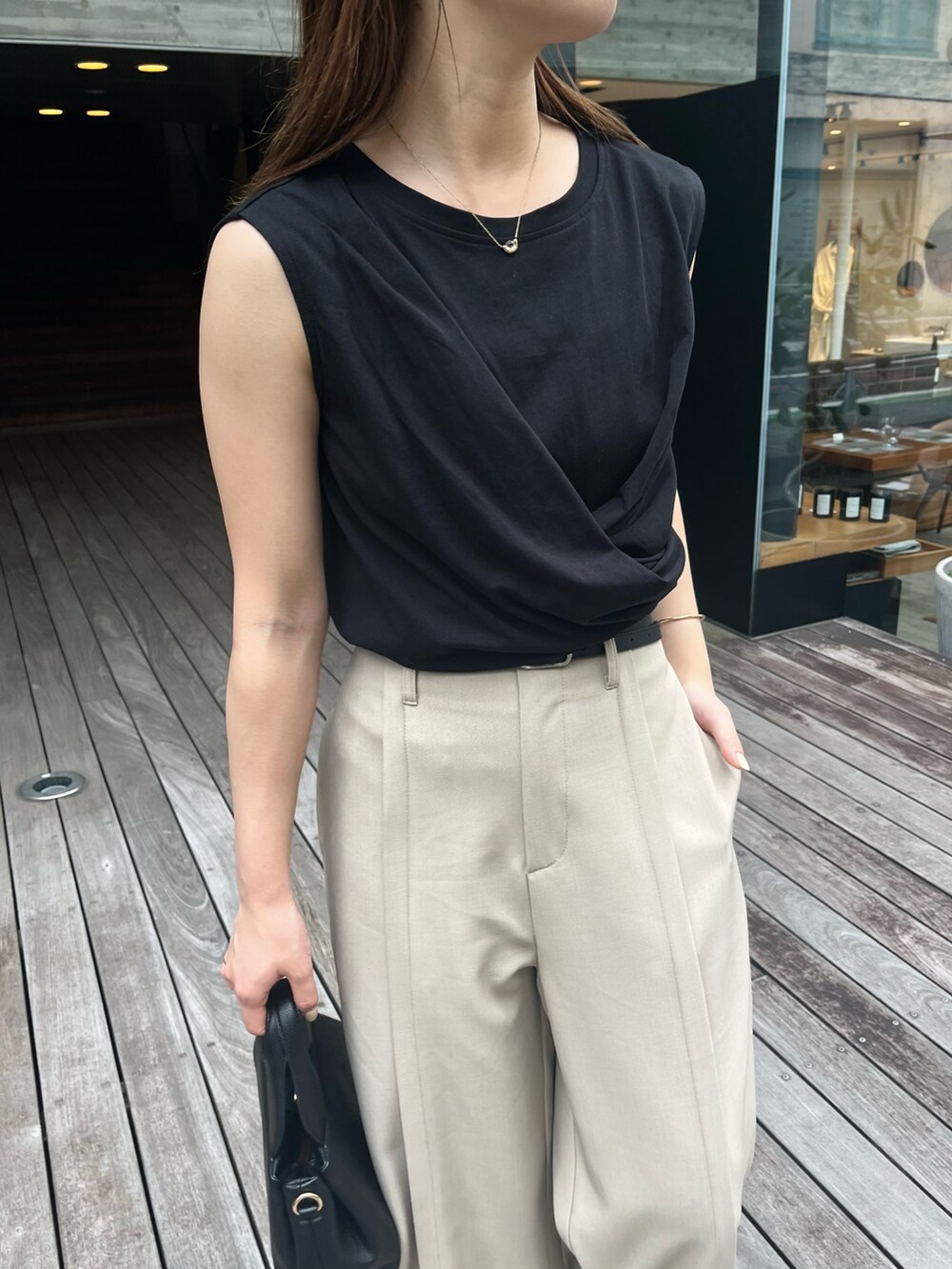 ブラック系のTシャツ/カットソー、ベージュ系のその他パンツ、ブラック系のショルダーバッグを着用したレディースの夏コーディネートの3枚目の写真