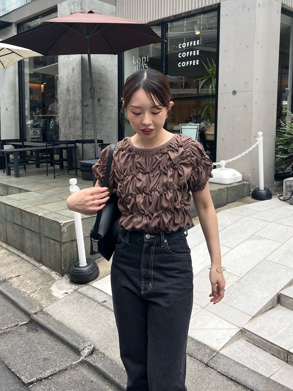 ブラウン系のTシャツ/カットソー、ブラック系のデニムパンツ、ブラック系のサンダルを着用したレディースの夏コーディネートの3枚目の写真