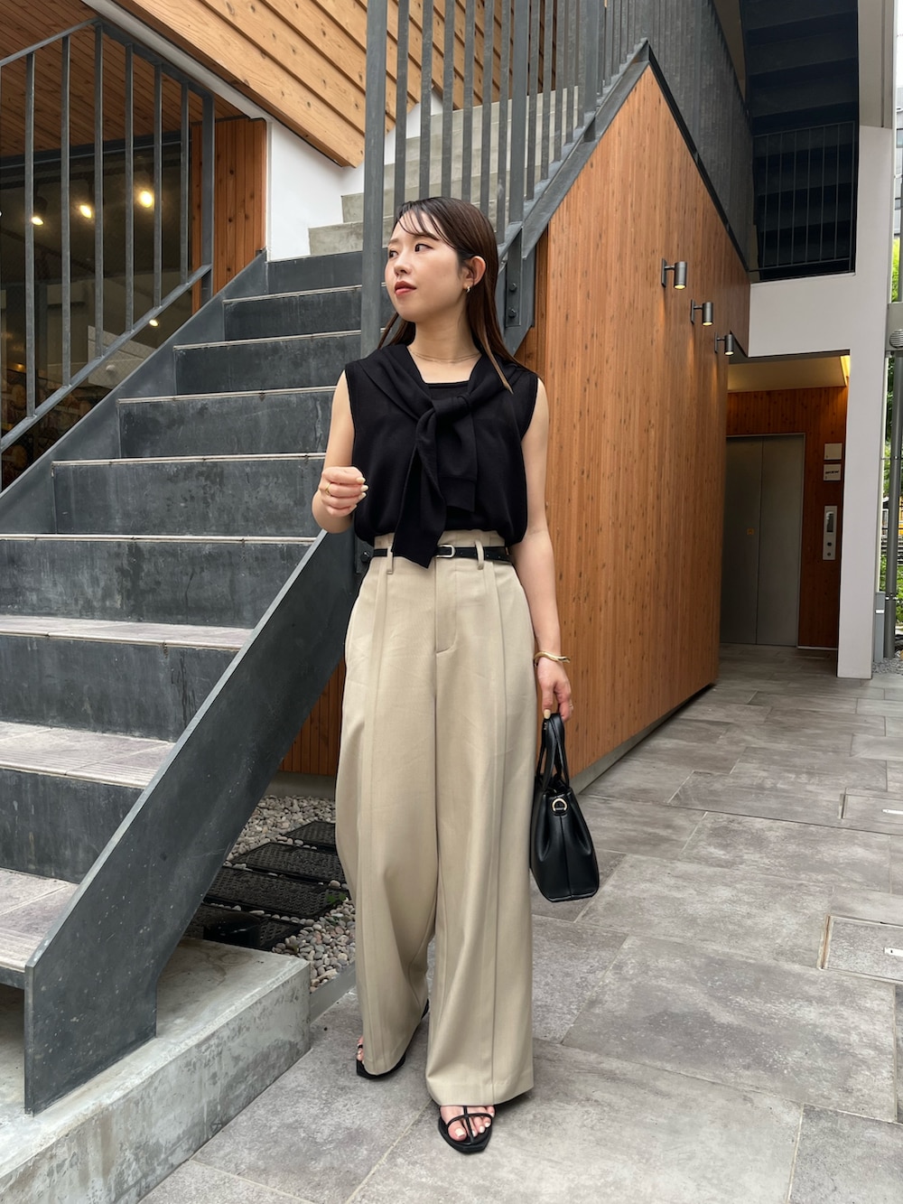 ブラック系のニット/セーター、ベージュ系のその他パンツ、ブラック系のサンダルを着用したレディースの夏コーディネートの4枚目の写真