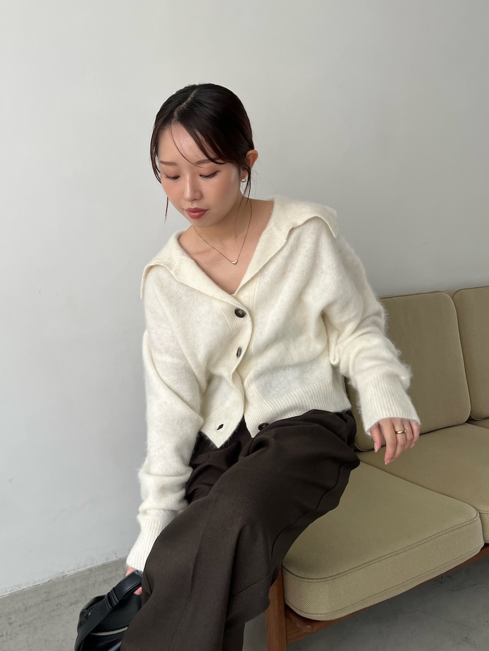 ホワイト系のカーディガン/ボレロ、ブラウン系のその他パンツ、ブラック系のパンプスを着用したレディースの秋コーディネートの2枚目の写真