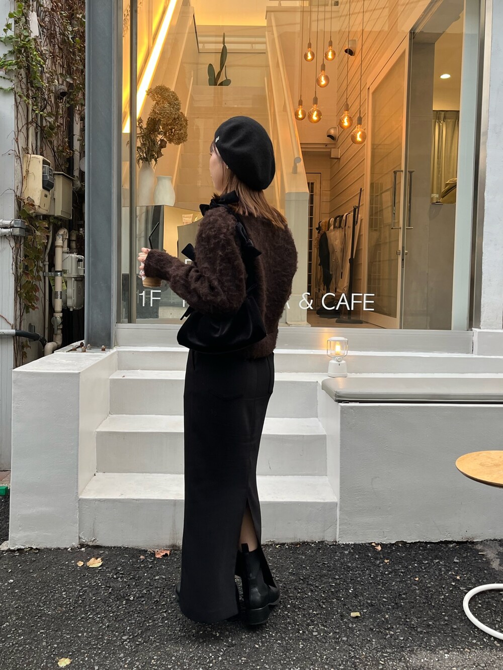 ブラウン系のカーディガン/ボレロ、ブラック系のスカート、ブラック系のパンプスを着用したレディースの秋コーディネートの4枚目の写真