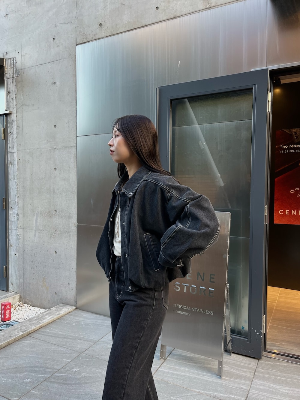 ブラック系のブルゾン、ベージュ系のTシャツ/カットソー、ブラック系のデニムパンツを着用したレディースの冬コーディネートの4枚目の写真