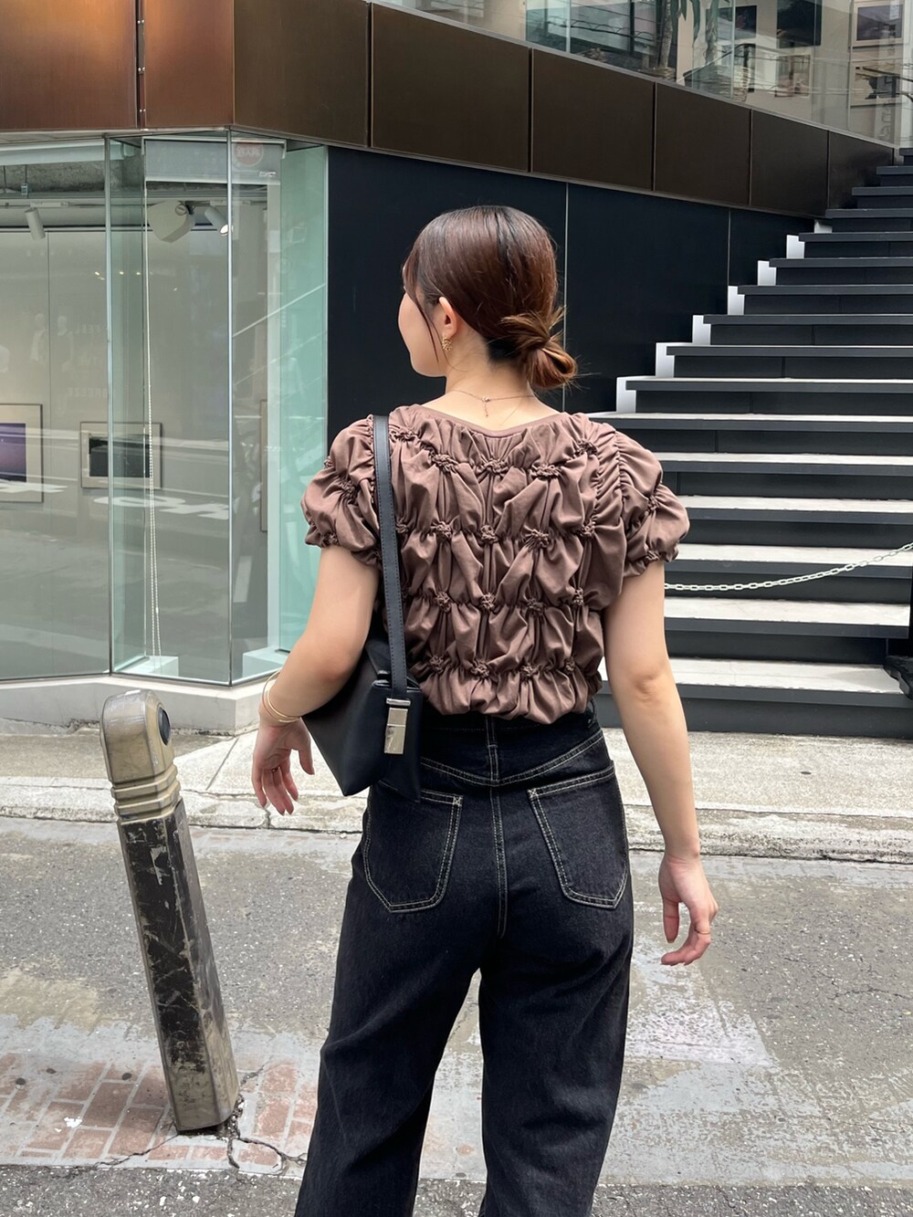 ブラウン系のTシャツ/カットソー、ブラック系のデニムパンツ、ブラック系のサンダルを着用したレディースの夏コーディネートの5枚目の写真