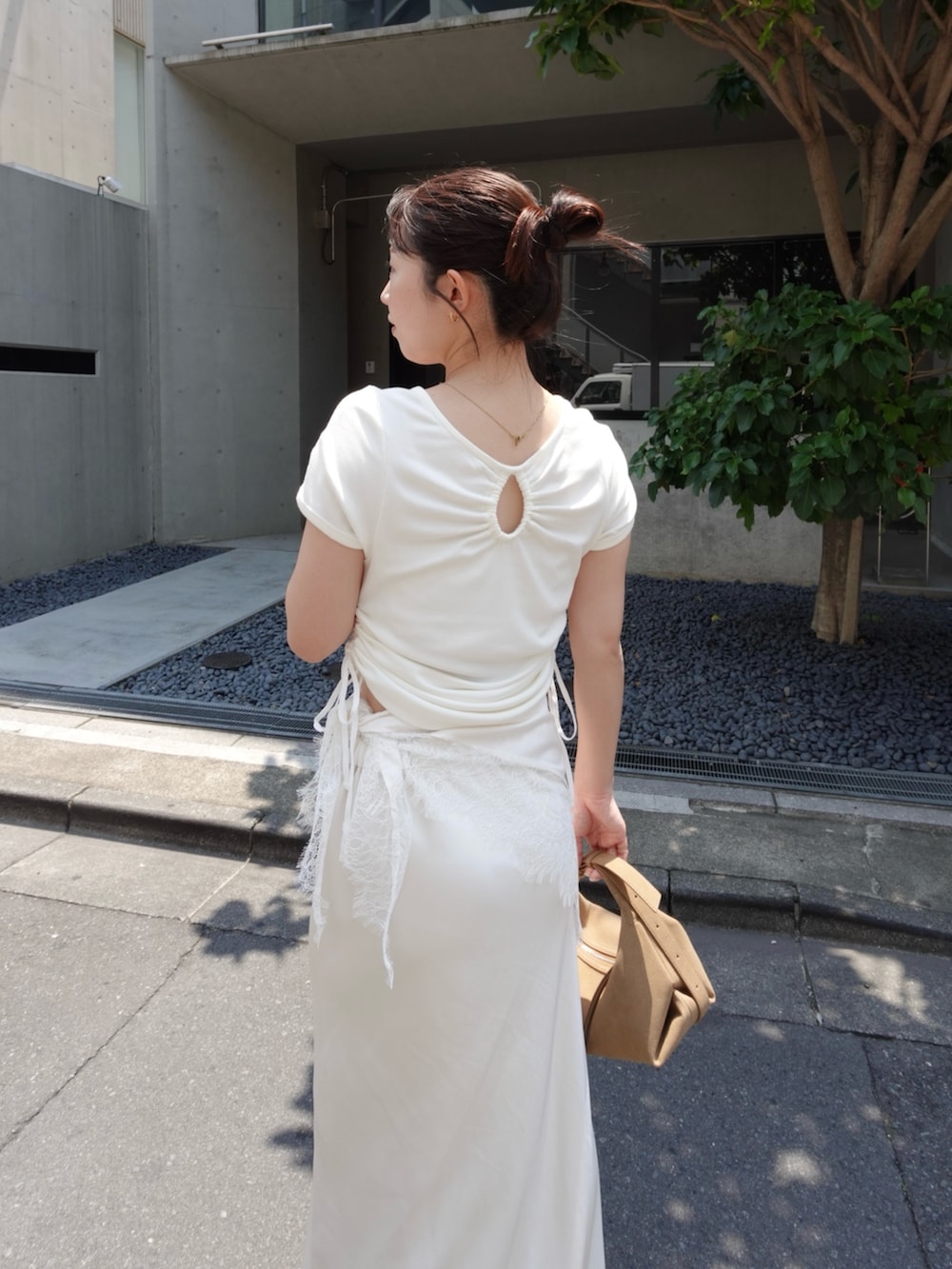 ホワイト系のTシャツ/カットソー、ホワイト系のスカート、ベージュ系のトートバッグを着用したレディースの夏コーディネートの5枚目の写真
