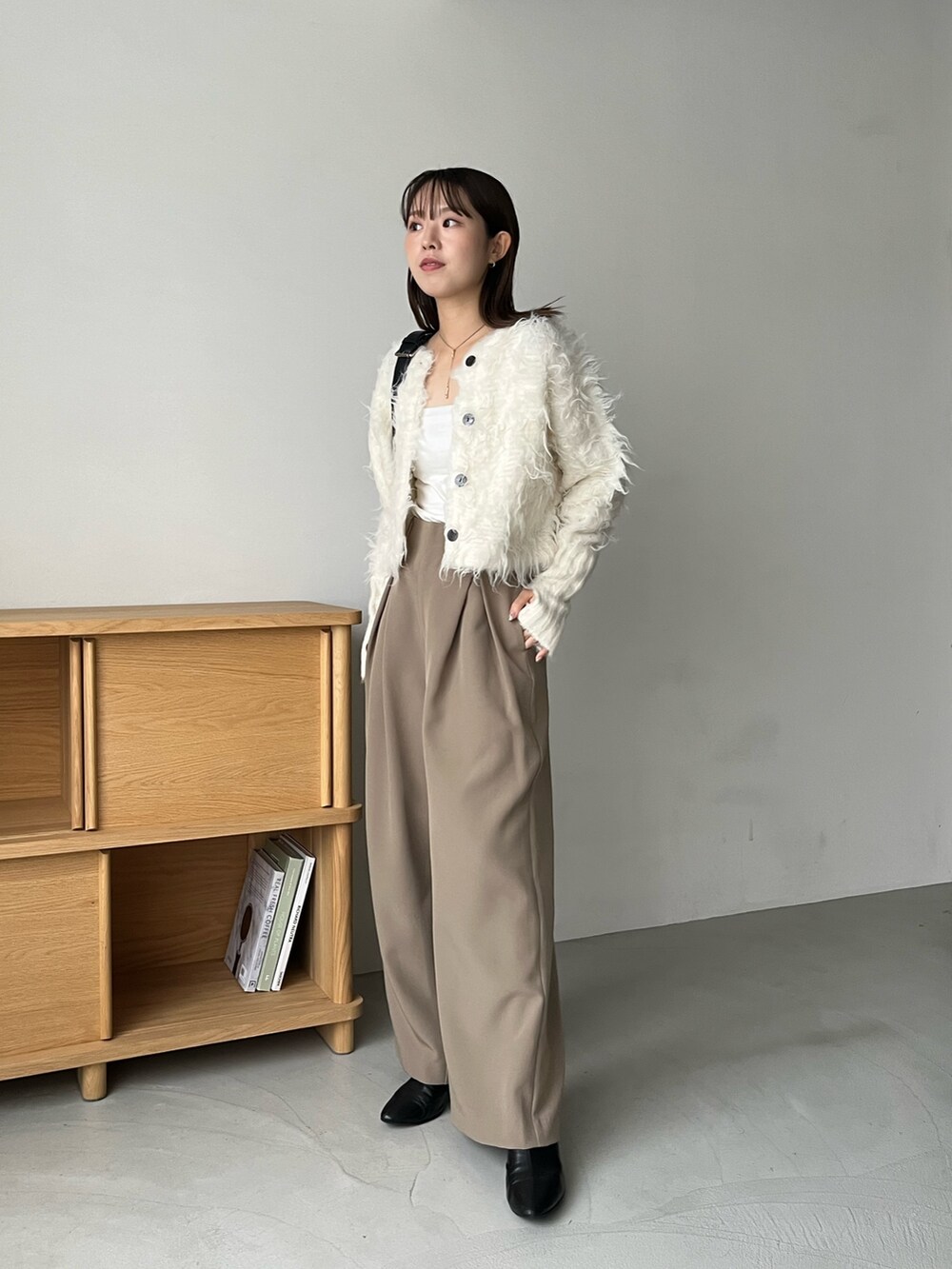 ホワイト系のカーディガン/ボレロ、ベージュ系のその他パンツ、ブラック系のショルダーバッグを着用したレディースの秋コーディネートの3枚目の写真