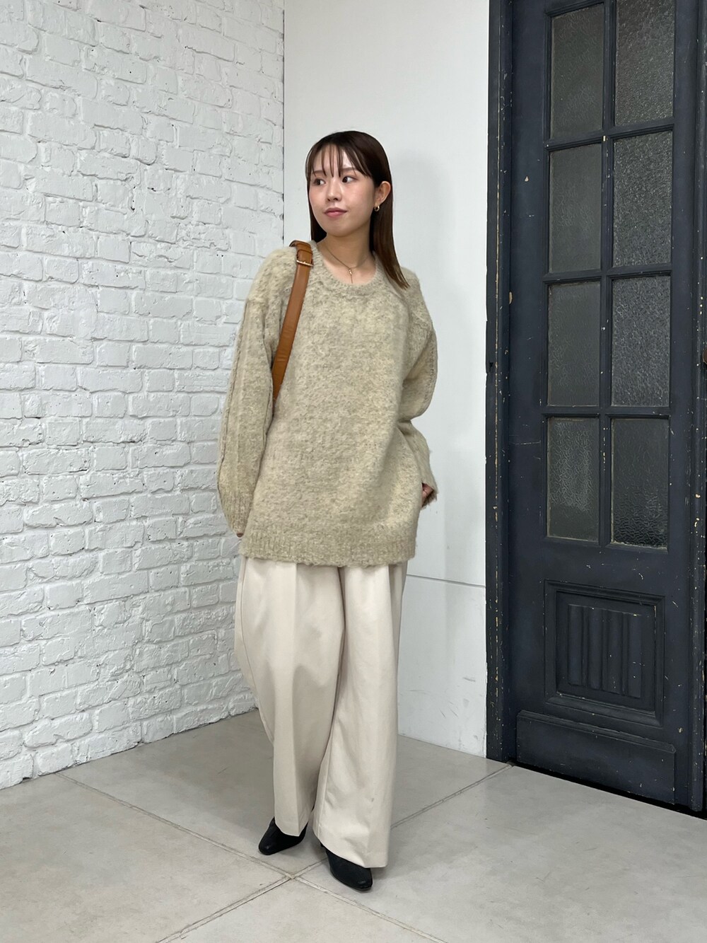 ベージュ系のニット/セーター、ホワイト系のその他パンツ、ベージュ系のショルダーバッグを着用したレディースの秋コーディネートの4枚目の写真