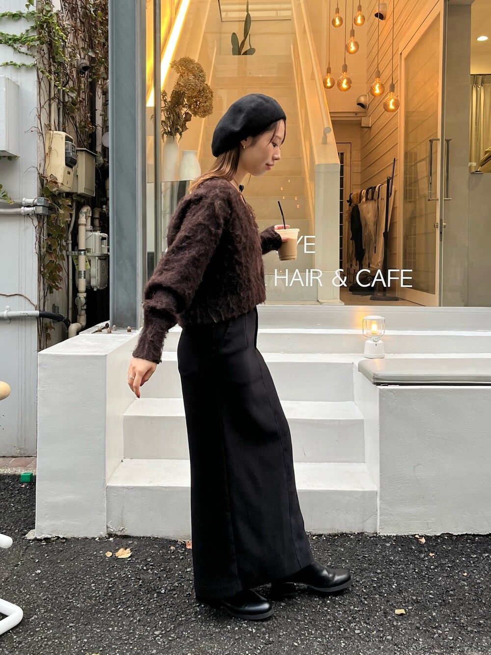 ブラウン系のカーディガン/ボレロ、ブラック系のスカート、ブラック系のパンプスを着用したレディースの秋コーディネートの3枚目の写真