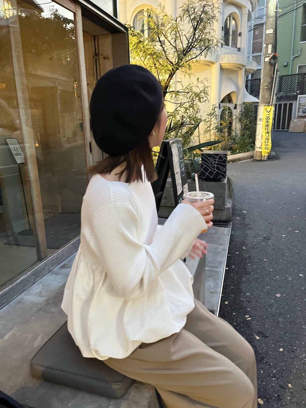 ホワイト系のニット/セーター、ベージュ系のその他パンツ、ブラック系のハンドバッグを着用したレディースの冬コーディネートの4枚目の写真