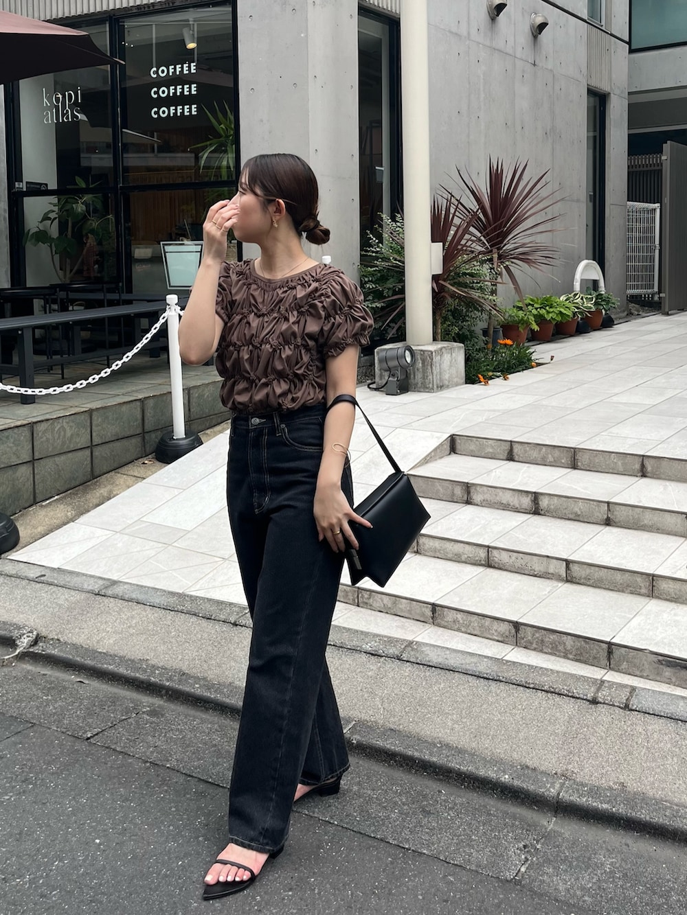 ブラウン系のTシャツ/カットソー、ブラック系のデニムパンツ、ブラック系のサンダルを着用したレディースの夏コーディネートの2枚目の写真