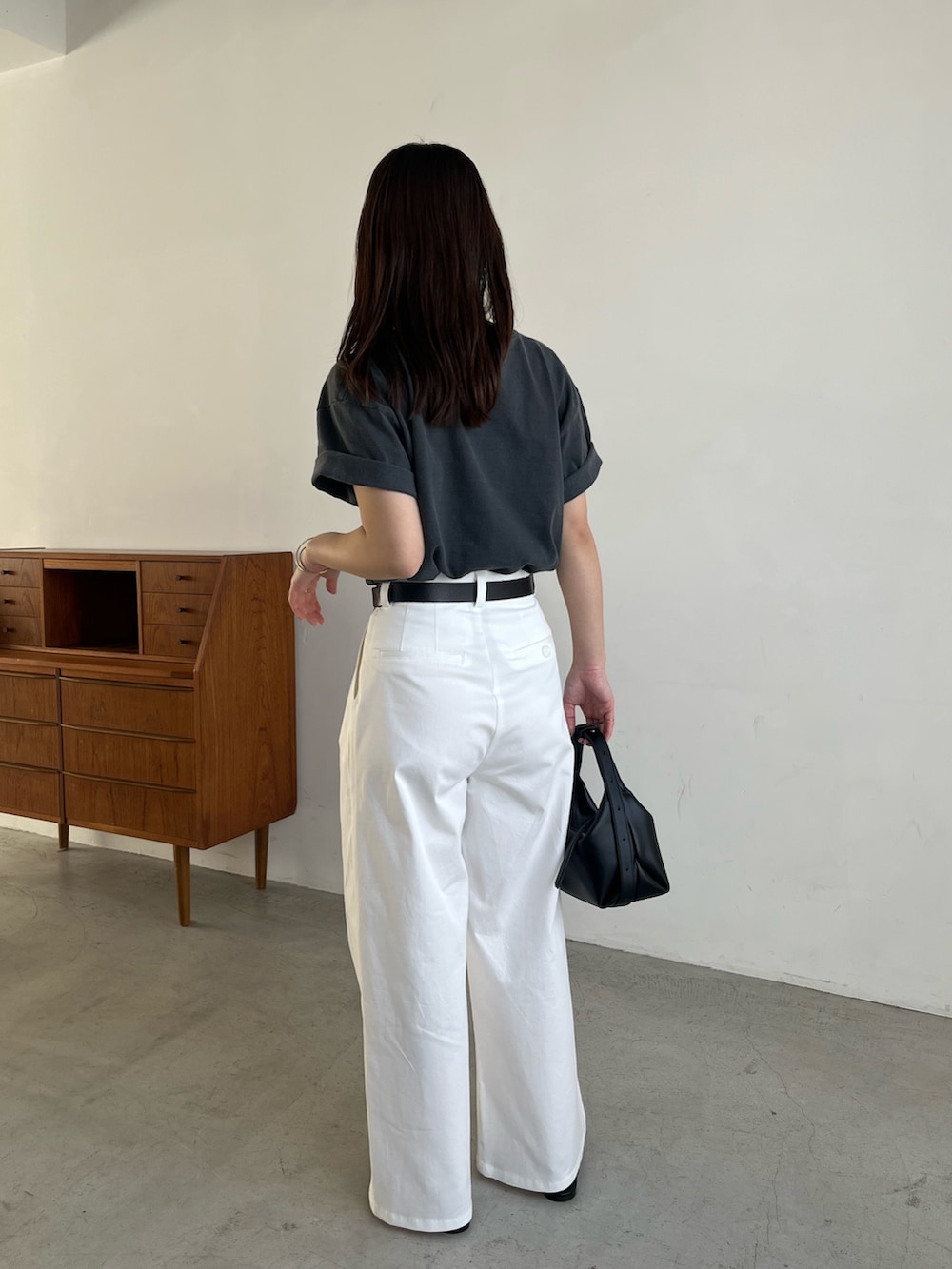 ブラック系のTシャツ/カットソー、ホワイト系のその他パンツ、ブラック系のサンダルを着用したレディースの春コーディネートの5枚目の写真