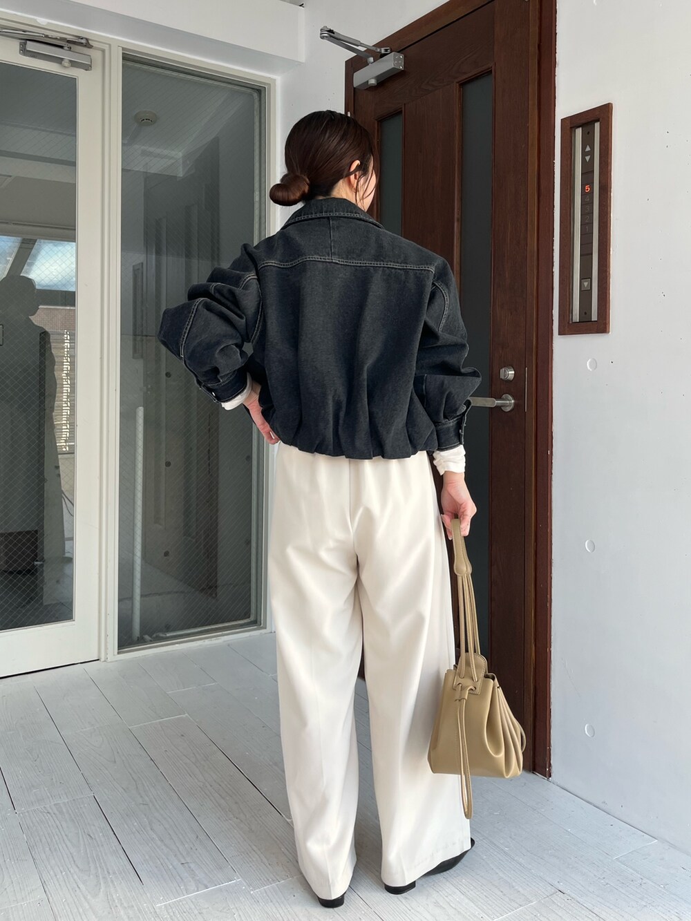 ホワイト系のTシャツ/カットソー、ブラック系のブルゾン、ホワイト系のその他パンツを着用したレディースの冬コーディネートの4枚目の写真