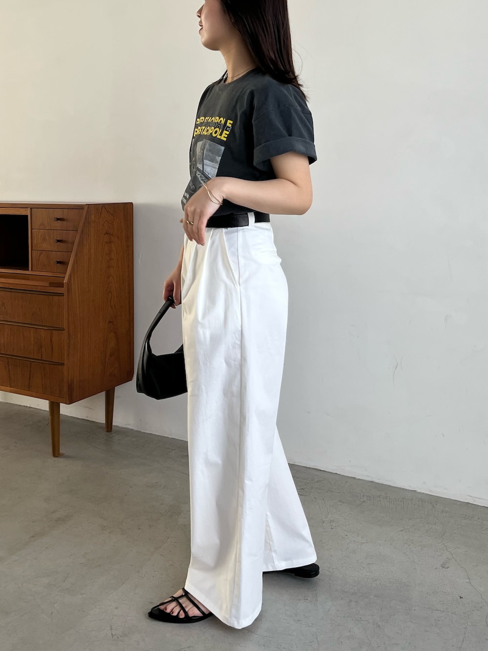 ブラック系のTシャツ/カットソー、ホワイト系のその他パンツ、ブラック系のサンダルを着用したレディースの春コーディネートの4枚目の写真