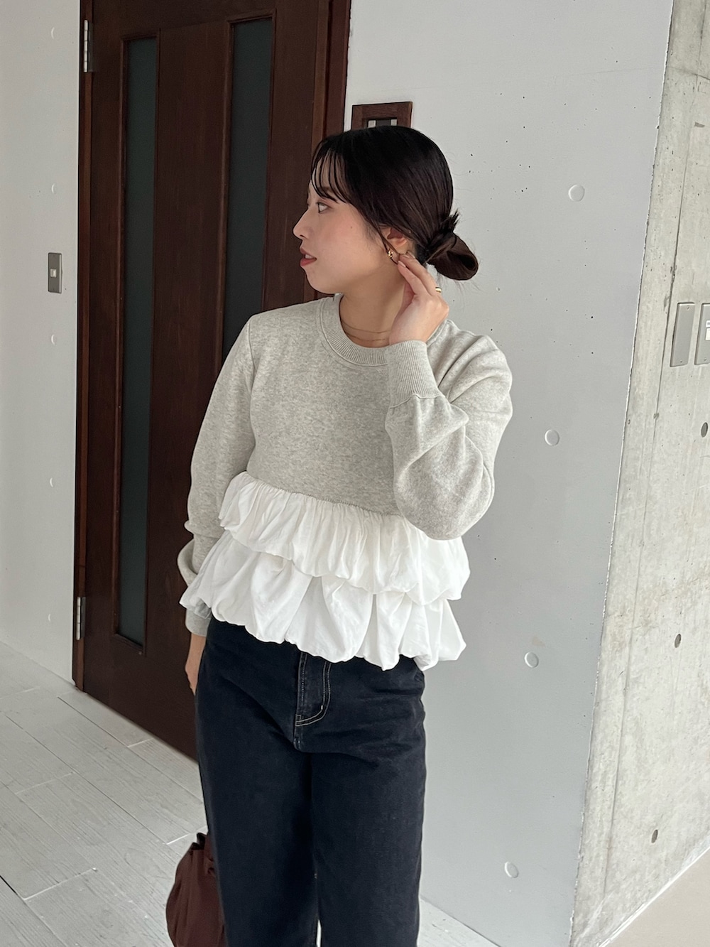 グレー系のニット/セーター、ブラック系のデニムパンツ、ブラック系のローファーを着用したレディースの冬コーディネートの2枚目の写真