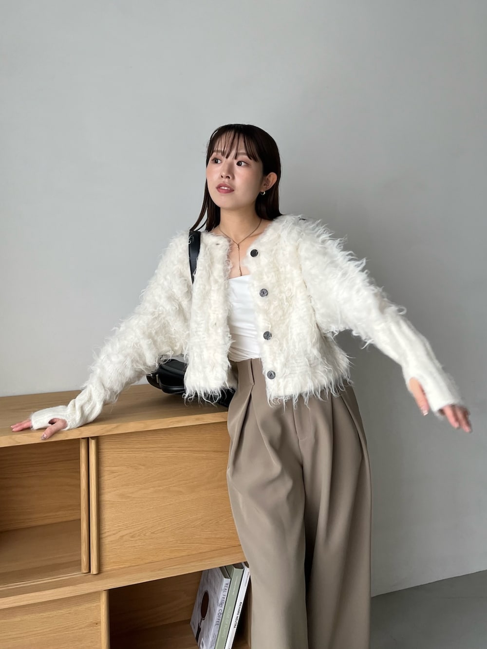 ホワイト系のカーディガン/ボレロ、ベージュ系のその他パンツ、ブラック系のショルダーバッグを着用したレディースの秋コーディネートの6枚目の写真