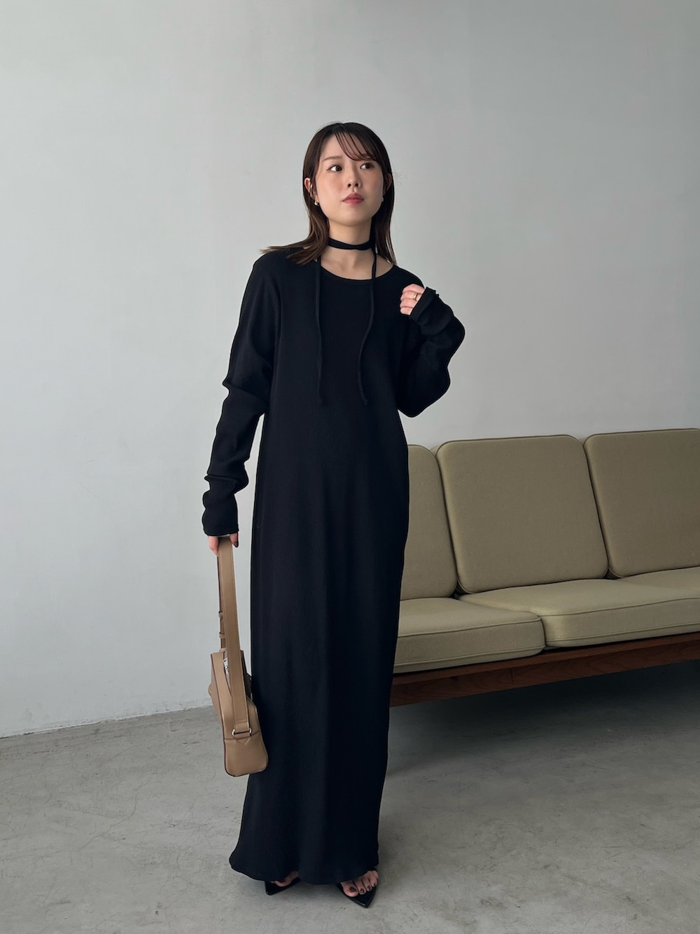 ブラック系のワンピース、ベージュ系のショルダーバッグ、ブラック系のサンダルを着用したレディースの春コーディネートの4枚目の写真