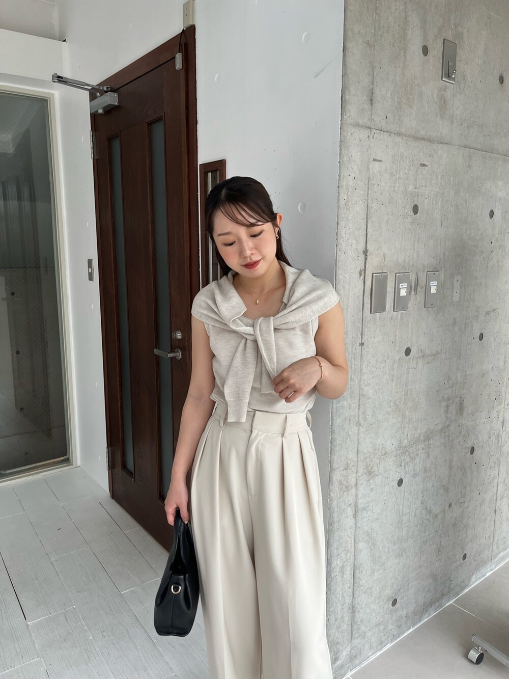 ホワイト系のニット/セーター、ホワイト系のその他パンツ、ブラック系のサンダルを着用したレディースの夏コーディネートの4枚目の写真