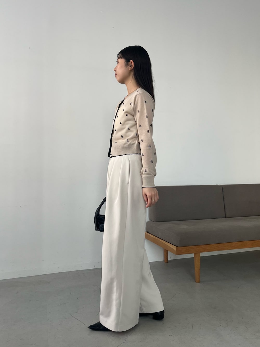 ベージュ系のカーディガン/ボレロ、ホワイト系のその他パンツ、ブラック系のショルダーバッグを着用したレディースの春コーディネートの3枚目の写真