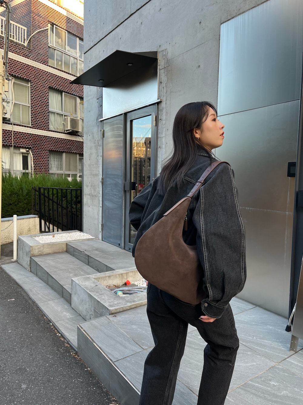 ブラック系のブルゾン、ベージュ系のTシャツ/カットソー、ブラック系のデニムパンツを着用したレディースの冬コーディネートの3枚目の写真