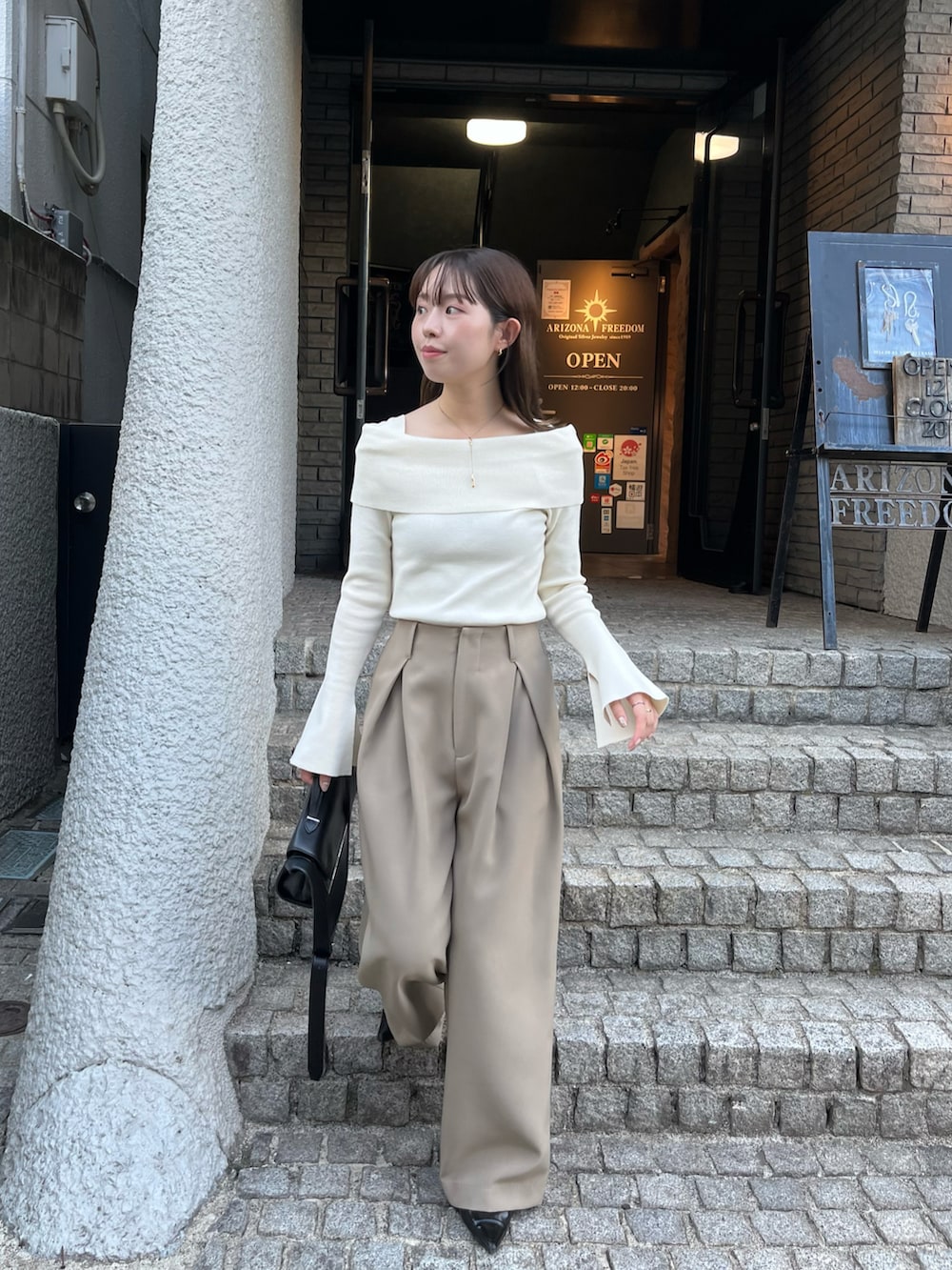 ホワイト系のニット/セーター、ベージュ系のその他パンツ、ブラック系のパンプスを着用したレディースの秋コーディネートの4枚目の写真