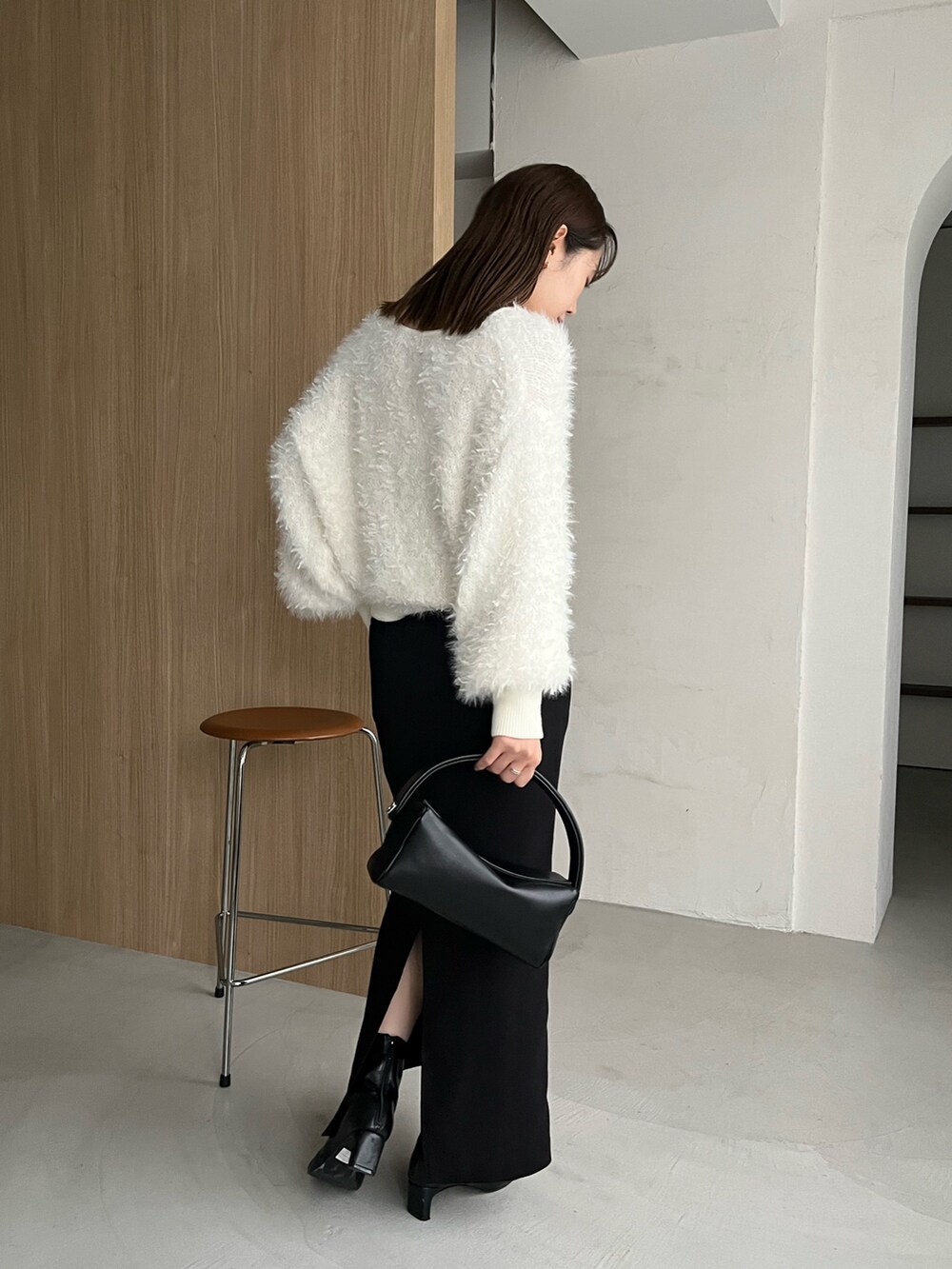 ホワイト系のカーディガン/ボレロ、ブラック系のスカート、ゴールド系のネックレスを着用したレディースの秋コーディネートの4枚目の写真