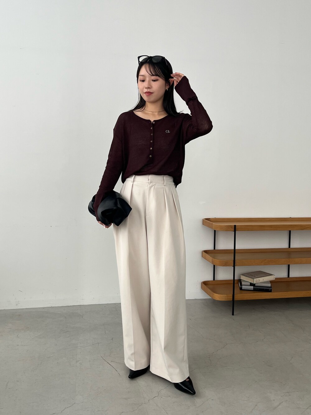 ブラウン系のニット/セーター、ホワイト系のその他パンツ、ブラック系のパンプスを着用したレディースの夏コーディネートの4枚目の写真