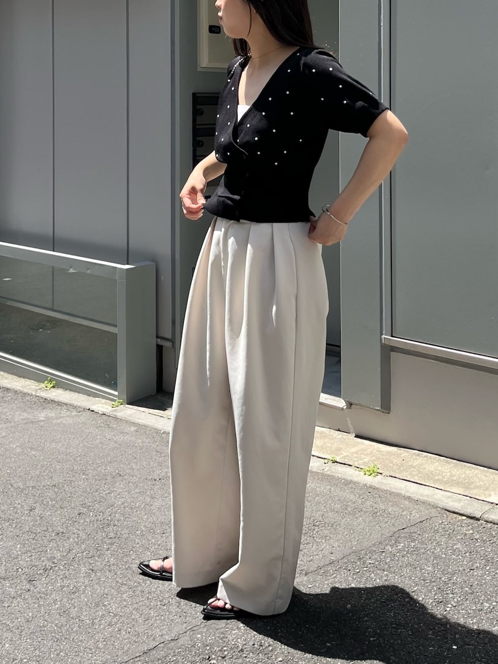 ブラック系のカーディガン/ボレロ、ブラック系のサンダル、ホワイト系のその他パンツを着用したレディースの夏コーディネートの4枚目の写真
